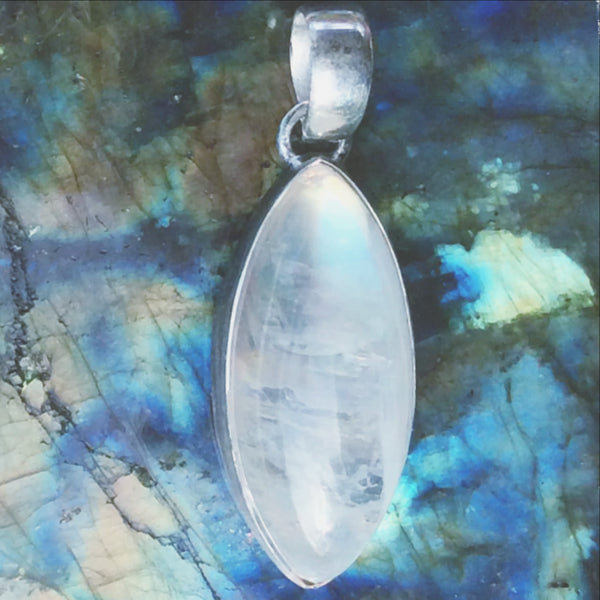 A stunning Rainbow Moonstone Pendant Marquis Style is simply set in sterling silver to place focus on the Moonstone's beautiful glow. The pendant is 1.5" x .5". New Earth Gifts